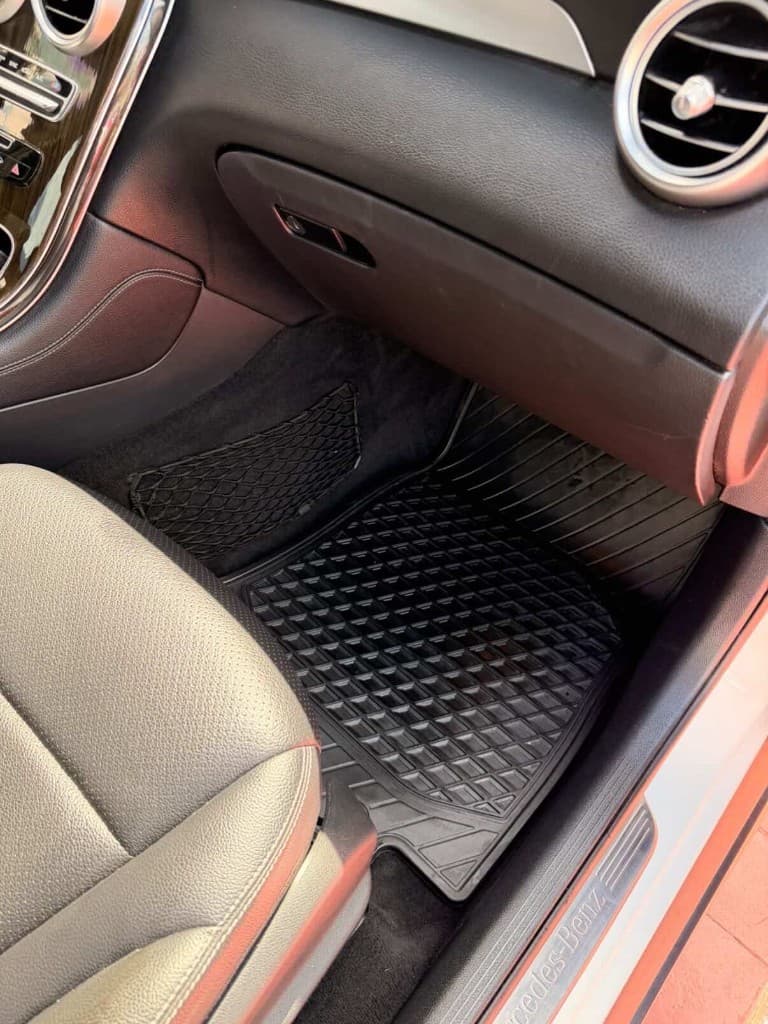 Passenger footwell with rubber floor mat conditioned