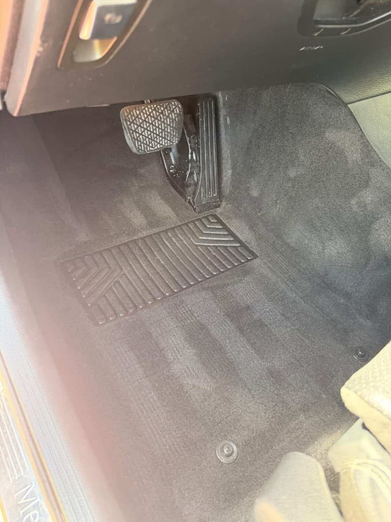 Driver footwell carpet with vacuum stripes