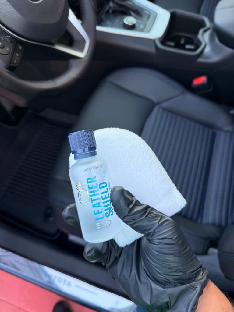 Technician applying Q2 Leather Shield coating inside a Toyota with leather and fabric seats